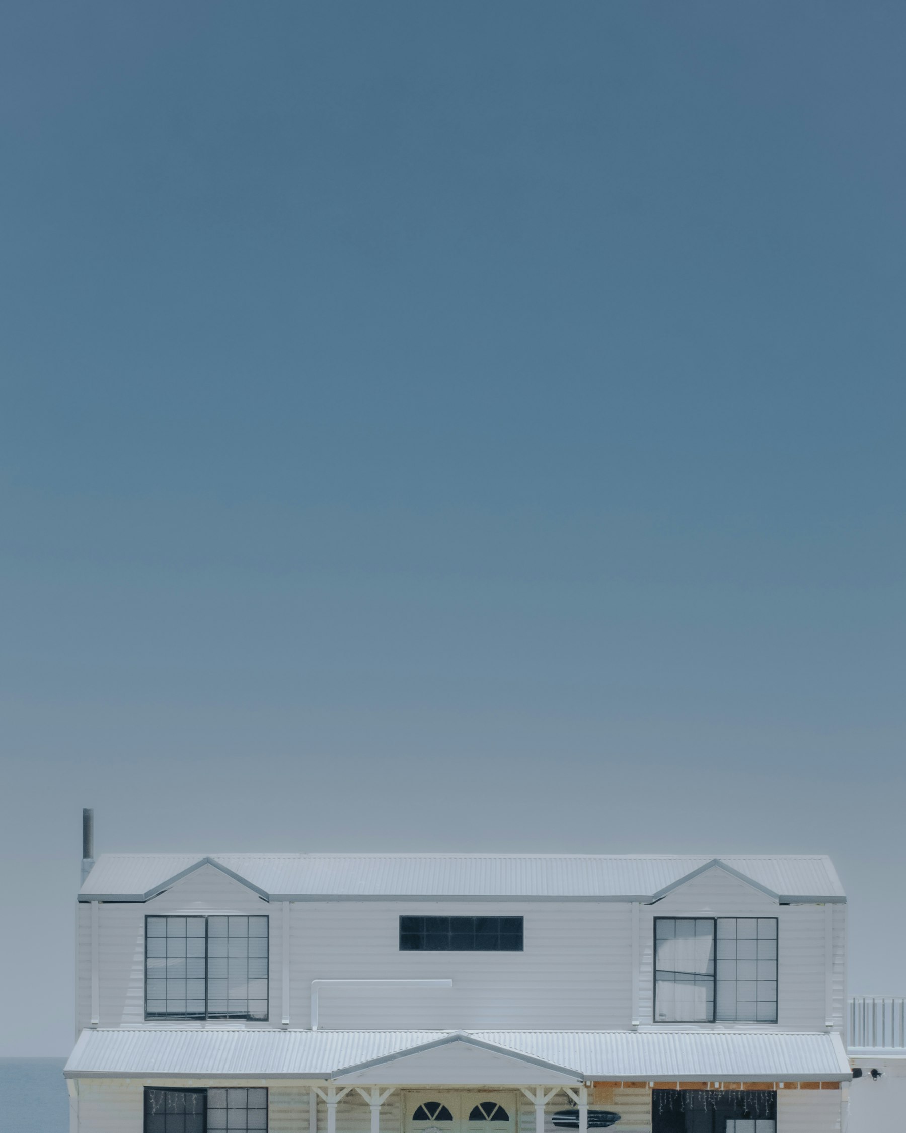 White Australian house beneath a wide blue sky
