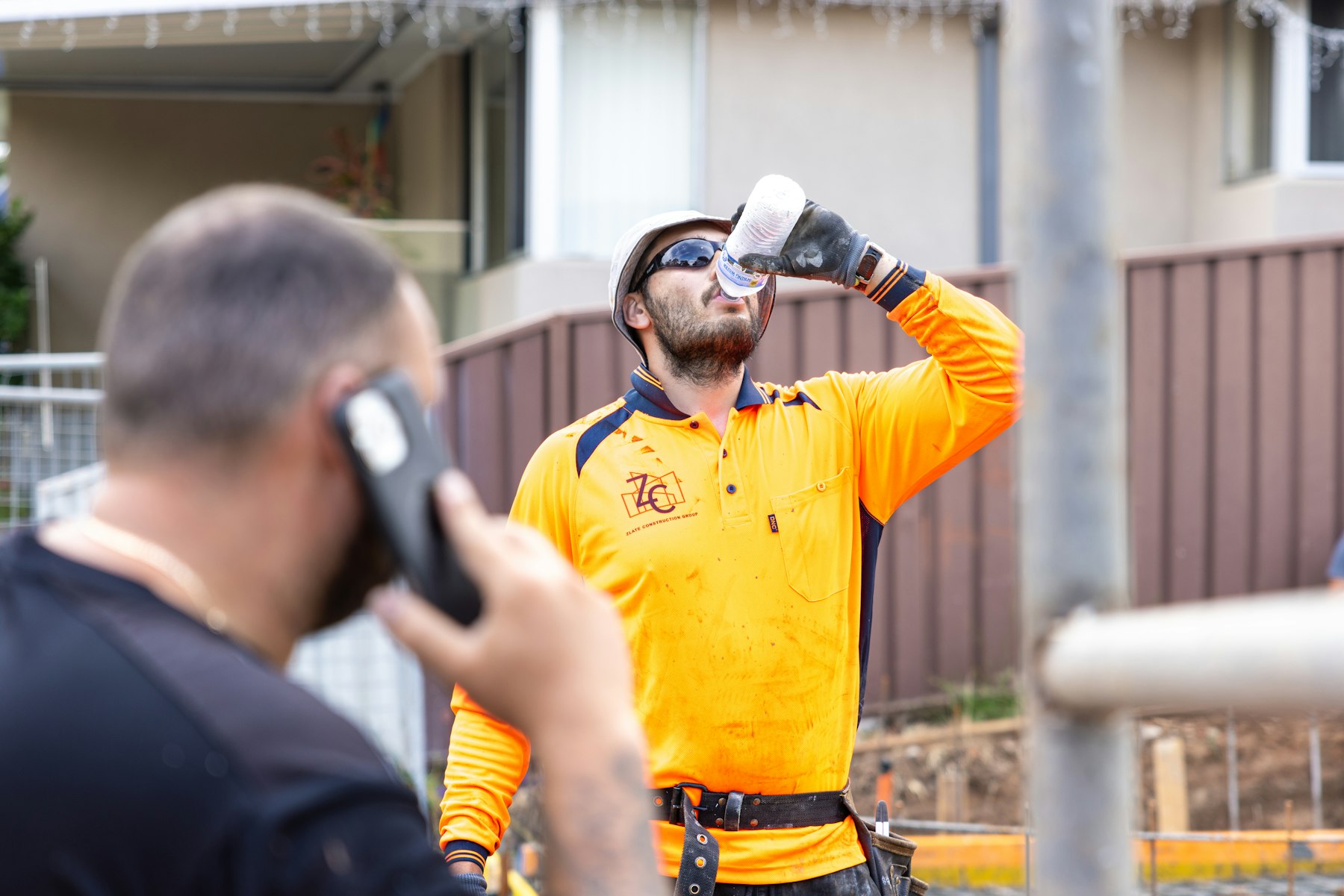 Field worker taking a break while a colleague uses a phone